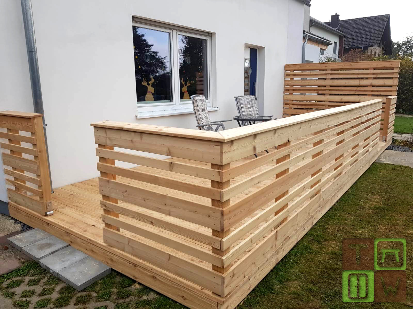 Holzterrasse mit Geländer und Sichtschutzwand